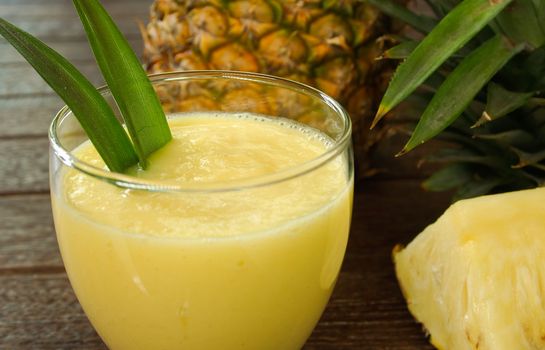 pineapple juice and pineapple on wood table. for health