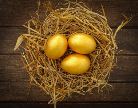 gold eggs in nest on wood background ,business concept