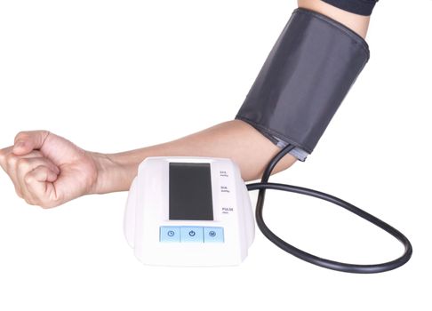 Woman checking blood pressure and heart rate with a digital blood pressure monitor on white background.