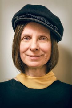 Portrait of a mature woman with a cap on the head. She could be a sailor, a worker, a docker, or even a gangster or a thug. She has a funny sweet face