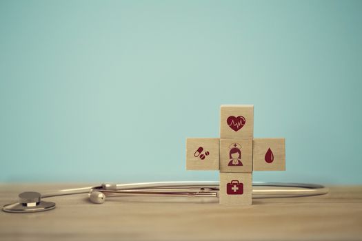 Healthcare concept about of health and medical insurance, arranging wood block stacking with icon healthcare medical on table wooden background.