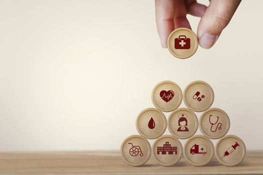 Healthcare concept about of health and medical insurance, Hand arranging block sphere stacking with icon health care medical on table wooden background.