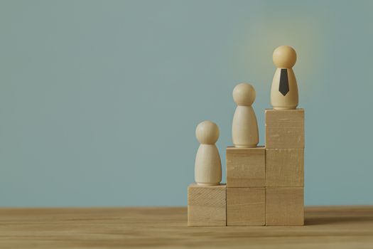 Successful business team leader concept: Businessman standing at the highest point on Wooden block. depicts of career growth up or business success.