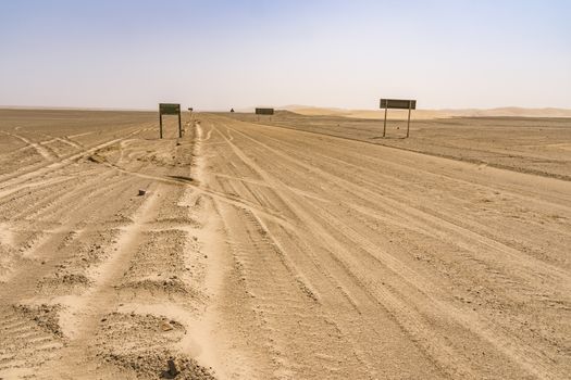 View of the Skeleton Coast desert dunes in Namibia in Africa with road signs.