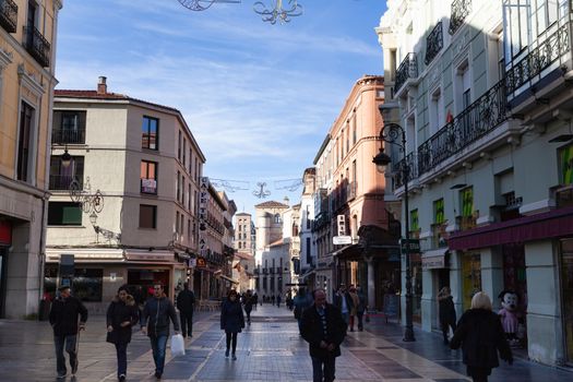 Leon, Spain - 10 December 2019: Calle Ancha (Ancha street), main shopping street in Leon with Palacio de los Guzmanes in the background