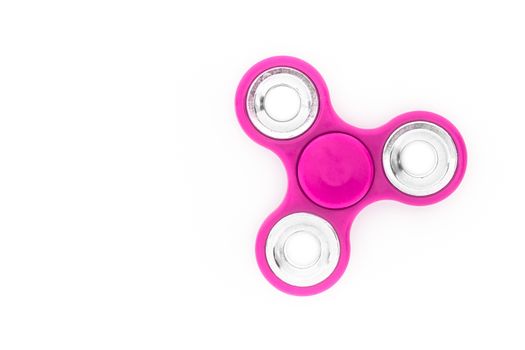 Pink finger spinner (stress anxiety relief toy) isolated on white background.