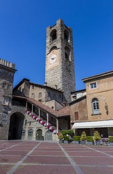 Bergamo - Upper town (Citta' Alta). Landscape on the the ancient Administration Headquarter called Palazzo della Ragione and the clock tower called Il Campanone in Old Square (Piazza Vecchia).