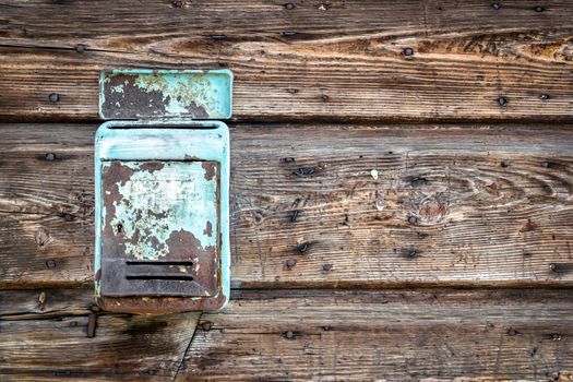 Rusty metal mailbox on the wooden doorway