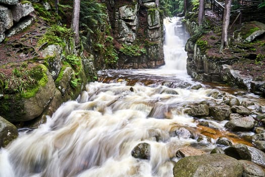 Rocks, boulders and waterfall in the forest in the Giant Mountains in Poland