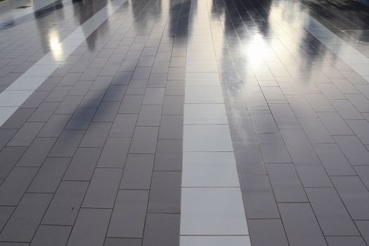 Diffuse reflections of pedestrians walking a marble sidewalk