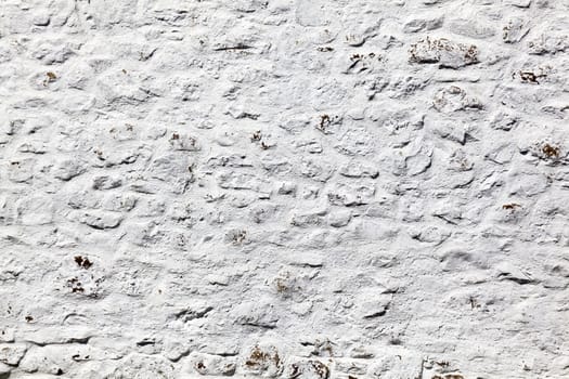 Old grey white weathered rough stone wall texture background