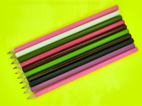 Colored pencil crayons on yellow background