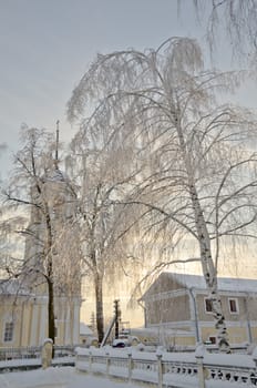 Winter view of the ancient bell tower in the Russian village Avdotieno, surrounded by frozen trees