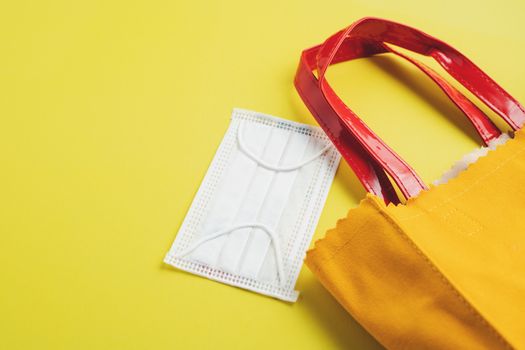 Hygiene face mask with shopping bag on yellow background for healthcare and new normal or new way of living concept