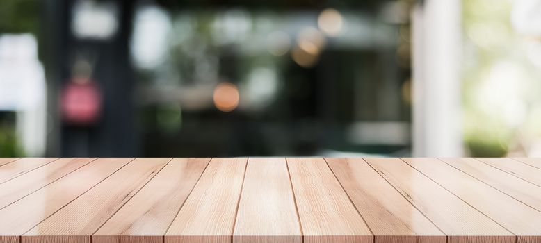 Empty wooden table top with lights bokeh on blur restaurant background