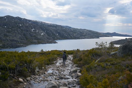 Woman girl hiking landscape in lake Lagoa comprida lagoon in Serra da Estrela, Portugal