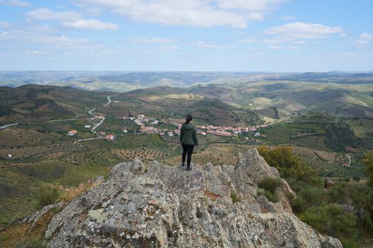 Woman social distancing looking at Castelo Melhor aerial view from miradouro de Sao Gabriel viewpoint