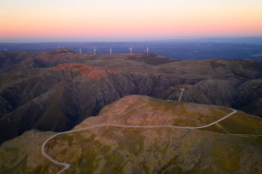 Serra da Freita drone aerial view in Arouca Geopark road with wind turbines at sunset, in Portugal