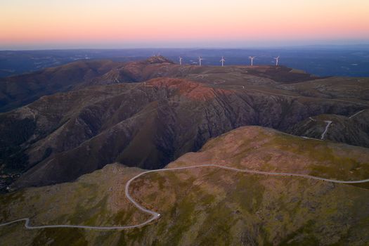 Serra da Freita drone aerial view in Arouca Geopark road with wind turbines at sunset, in Portugal