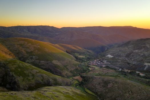 Serra da Freita drone aerial view in Arouca Geopark road with wind turbines at sunset, in Portugal