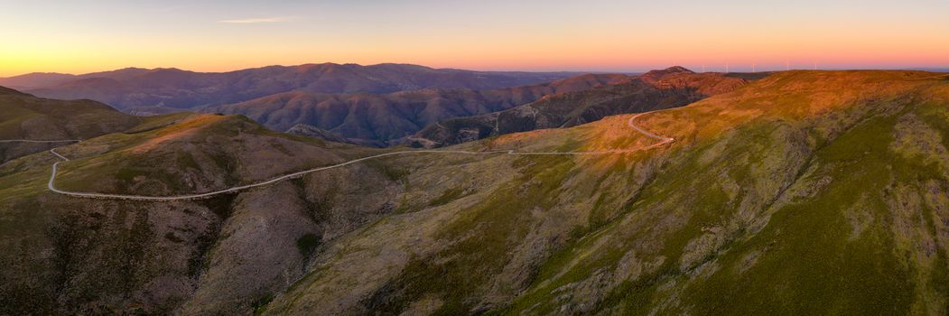 Serra da Freita drone aerial panorama view in Arouca Geopark road with wind turbines at sunset, in Portugal