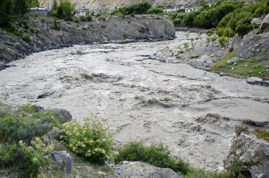 Fast, affluent and muddy mountain Nepal river near Jomsom village