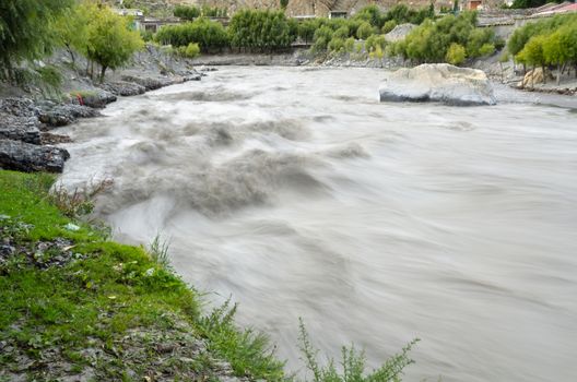 Fast, affluent and muddy mountain Nepal river near Jomsom village