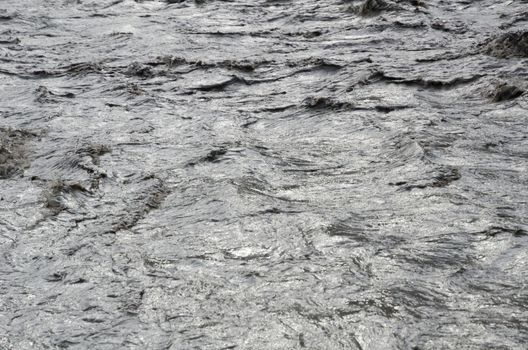 Fast, affluent and muddy mountain Nepal river near Jomsom village