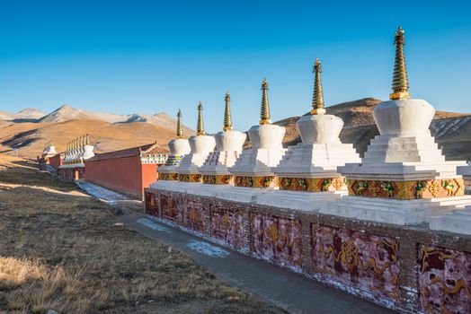 Buddhist stupas are shine under the sunset light at a Tibetan monastery at Madoi County