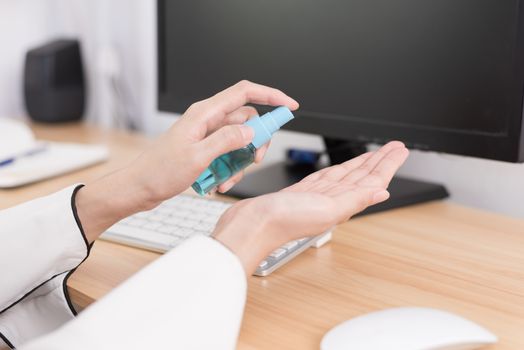 A beautiful Asian businesswoman cleaning hands by cleaner gel to protect COVID-19 before start working from home with safety and happiness.