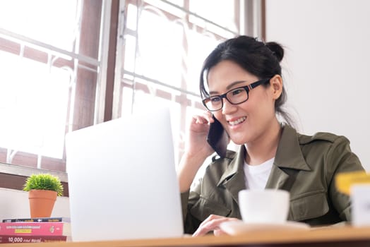 Modern young Asian woman working from home and talking with a partner about her business with happy and smile.