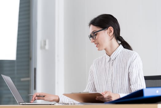 A businesswoman wearing glasses working with smiling and happiness at the office.