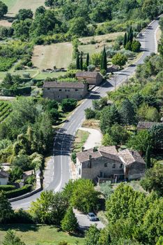 Modern twisted asphaltic road across a small green village of Provence