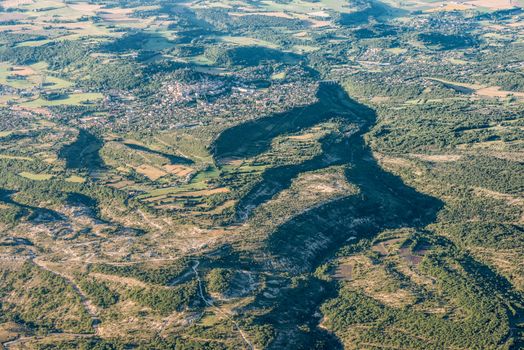 Mid-air view of green hills and cultivated land near Forcalquier city, Provence