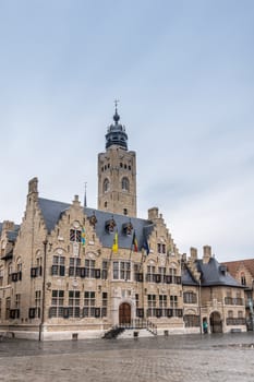 Diksmuide, Flanders, Belgium -  June 19, 2019: Grote Markt. Brown brick historic City Hall, or Stadhuis, building under light blue sky. Rain Wet market square.