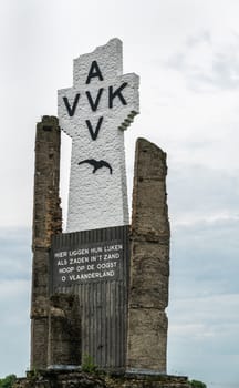 Diksmuide, Flanders, Belgium -  June 19, 2019: Closeup of Black on White Crypt memorial, remnants of dynamited tower, at site of IJzertoren, tallest peace monument of WW 1 against gray cloudscape.