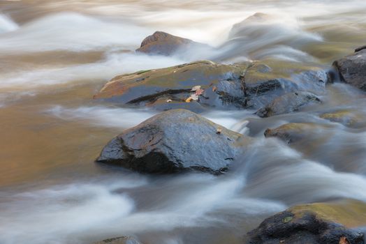 Close up view of a stony riverbed and silver stream near Emsdale town, Ontario, Canada