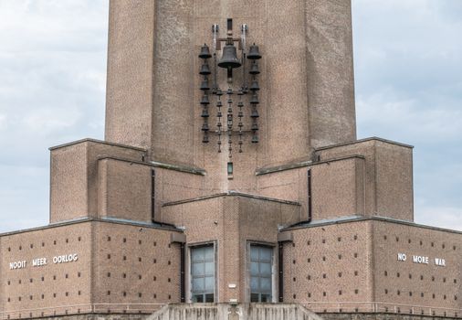 Diksmuide, Flanders, Belgium -  June 19, 2019: Foot of medestal of IJzertoren, tallest peace monument of WW 1. Text read No More War in Dutch and English. Carilon on brick wall.