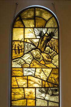 Diksmuide, Flanders, Belgium -  June 19, 2019: Yellowish Stained glass window in chapel of IJzertoren, depicting dead brothers Van Raemdonck, Flemish iconic soldiers.