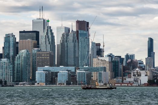 A small ship carries tourists from Algonquin Island to the Old Toronto skyscrapers, Canada