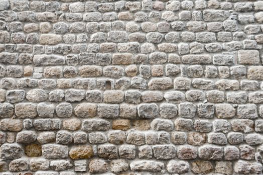 Close up view of a textured ancient stone wall of a historical building