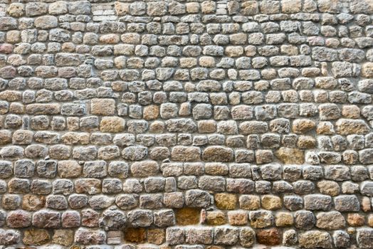 Frontal view of a broken textured ancient stone wall of a historical building