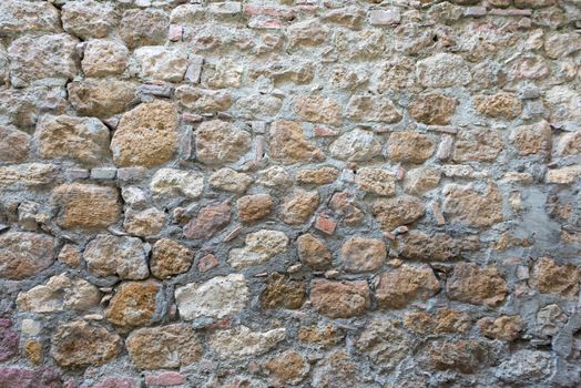 Close view of an aged cracked stone wall of a historical building