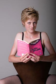 Attractive Blonde WOman Reading Sex Tips Book