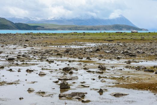 Shallow water at Lake Tekapo reveals a lot of small stones, New Zealand