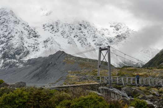 Snowy mountain scenery and hanging bridge at Hooker Valley Track, Mount Cook National Park, New Zealand
