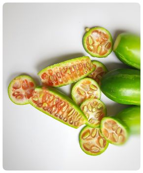 fresh scarlet gourd and it cut into pieces round and vertical shape in white plate dietary supplement and prevent high cholesterol to high blood pressure