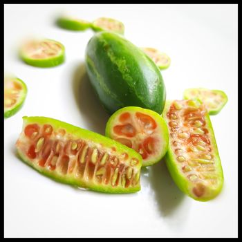 fresh scarlet gourd and it cut into pieces round and vertical shape in white plate dietary supplement and prevent high cholesterol to high blood pressure