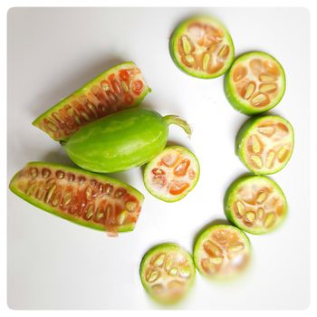 fresh scarlet gourd and it cut into pieces round and vertical shape in white plate dietary supplement and prevent high cholesterol to high blood pressure