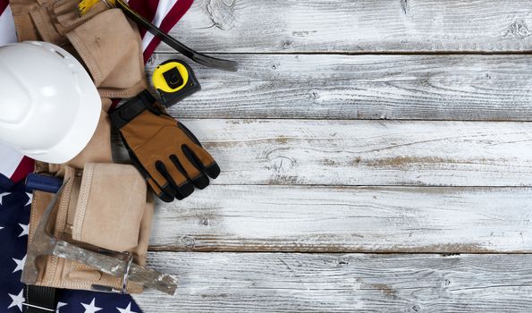 US Happy Labor Day concept with national flag and leather pouch containing industrial work tools on white rustic wooden background 